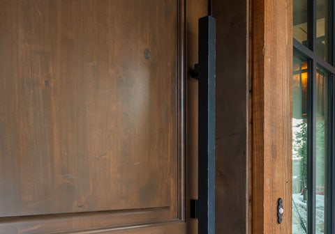 Dark wooden door with long modern black handle