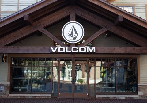 Volcom store front with large logo, glass doors, and wooden architectural elements